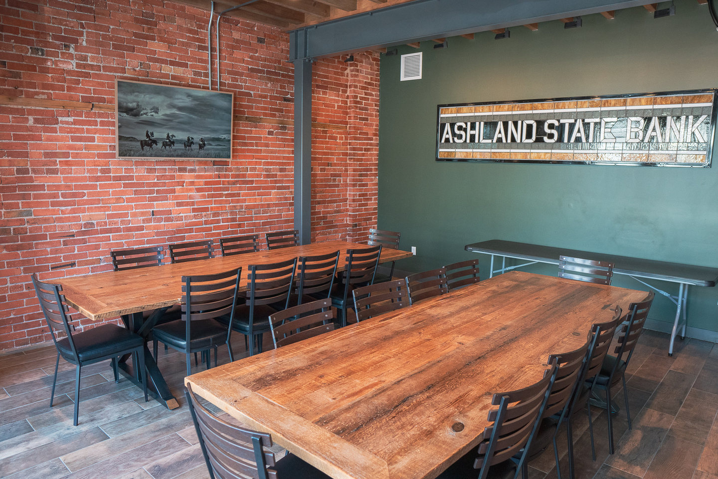 Long wooden tables and original brick in the Ashland State Bank Room